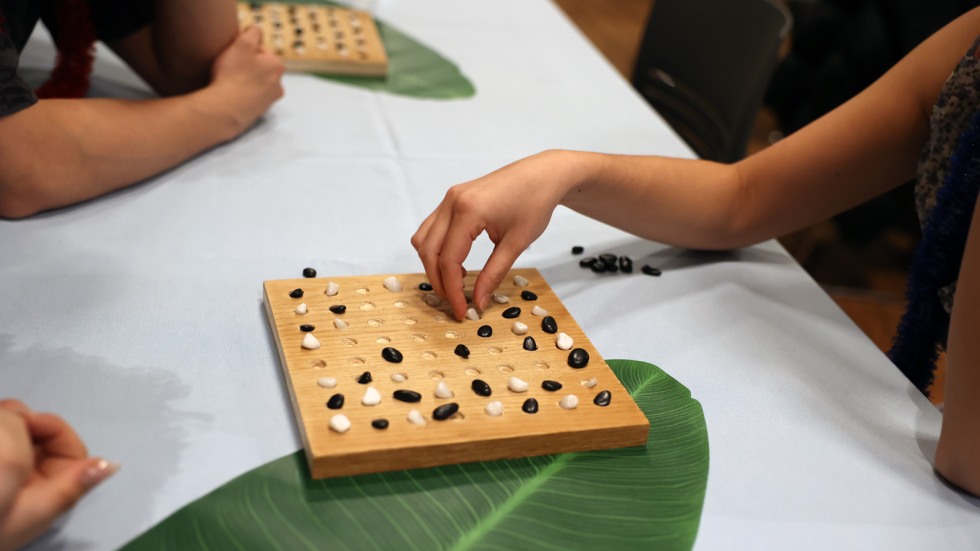 Detail shot of hands playing game of konane